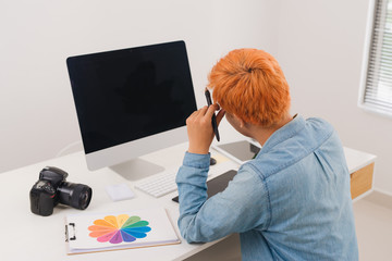 Photographer sitting at desk retouching new photos in his studio
