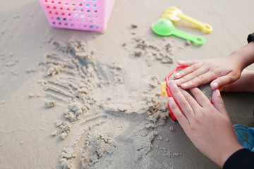 Little children play toys on the beach