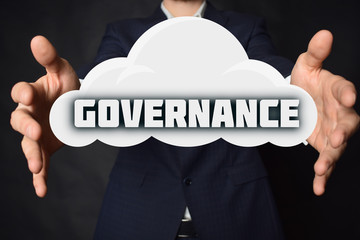 In the hands of a businessman, a cloud with the inscription:GOVERNANCE