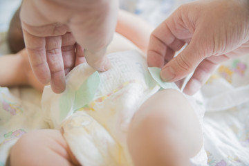 Fototapeta na wymiar close-up of hands wearing baby diapers