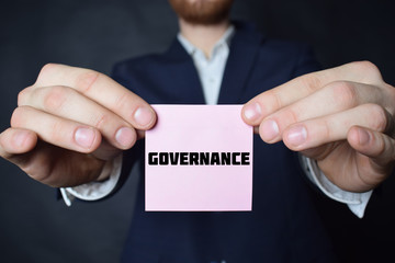 A businessman shows an inscription:GOVERNANCE