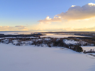 Aerial drone view of a winter landscape. Snow covered forest and lakes from the top. Sunrise in  nature from a birds eye view. Aerial photography. Aerial photo. Quadcopter.