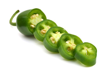 sliced green chilies on white background