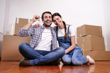 Portrait of a beautiful smiling couple of lovers just arrived in the new house to start a new journey together. Concept of: love, family, home.