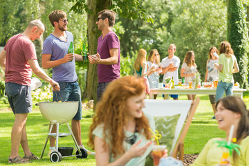 Friends grill and laugh in park