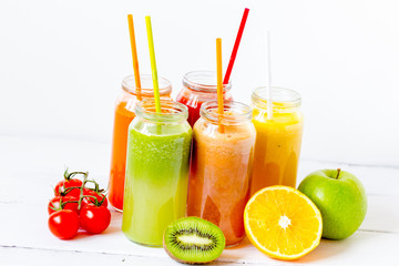 Fresh detox juices in glass bottles on white background