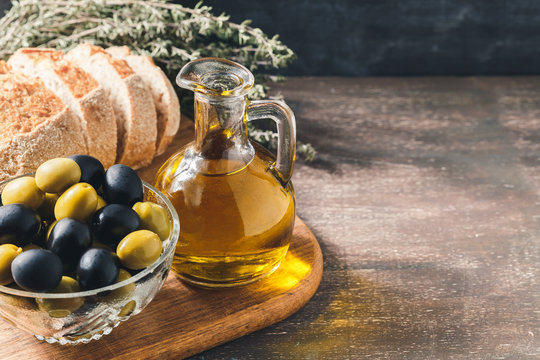 Glass bottle of olive oil with olives
