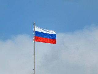 Fototapeta na wymiar Russian flag on the background of the cloudy blue sky. National flag of Russia over Red square in Moscow