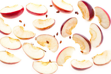 Slices of fresh red apple and seeds, isolated on white background, top view.