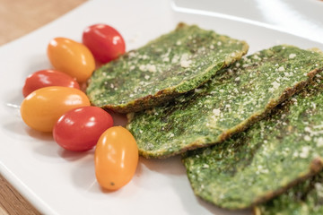 Spinach pancakes with cherry tomatoes. - 198473746