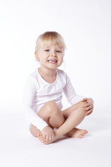 Barefoot girl sitting on floor at studio shot .