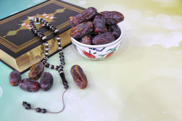 Three months.Islamic Holy Book Quran under soft light on White Background. Ramadan concept . The Koran with rosary beads and date.