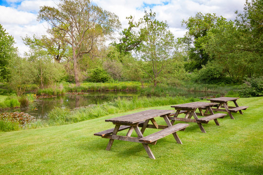 Picnic tables by a pond in Southern England UK