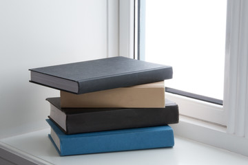 stacked books windowsill