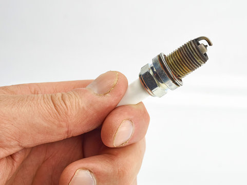 Car spark plug old in hand isolate