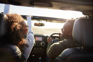Couple drive looking at each other, rear passenger POV