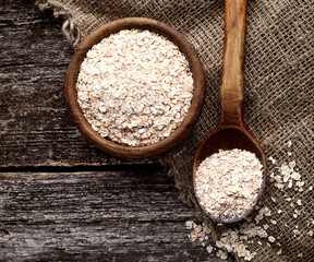 Oatmeal or oat flakes on dark wooden table