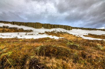 The stunning basalt columns with a dramatic cloudscape in the background in Iceland
