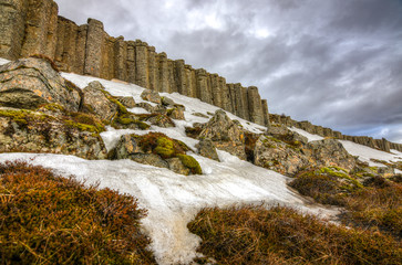 The stunning basalt columns with a dramatic cloudscape in the background in Iceland