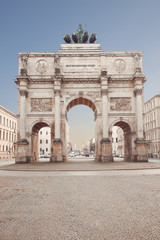 Fototapeta na wymiar The Siegestor in Munich, Germany. Victory Gate, triumphal arch crowned with a statue of Bavaria with a lion-quadriga. Located between the Ludwig Maximilian University and the Ohmstrasse.