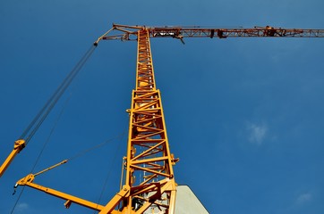 Yellow construction crane seen from bellow