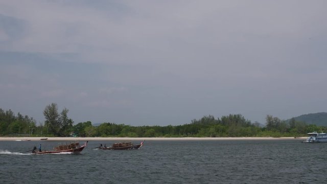Traditional thai wooden boat loaded with fish trap sail in the sea.