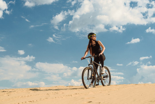 Sport and recreation. Full length image of young female cyclist. Athlete girl is running with her extreme bike outdoors.