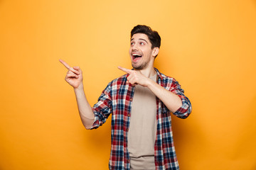 Portrait of an excited young man pointing fingers away