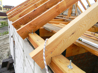 Roofing construction with wooden beams, logs, rafters, trusses.