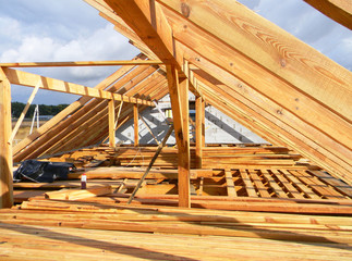 Installing wooden beams, logs, timber, rafters, trusses for house attic construction. Roofing construction.