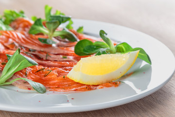 salted salmon with a slice of lemon on a sheet of green salad