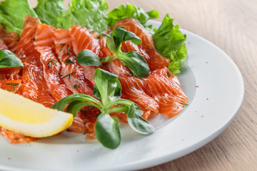 salted salmon with a slice of lemon on a sheet of green salad