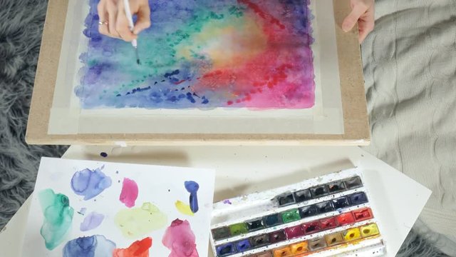 Adult women paint with colored watercolor paints in an art school close up