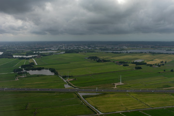 Farms, Highway in Holland, Netherlands with canal viewed from plane in sky with clouds