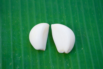 peeled cloves of garlic on green leaf