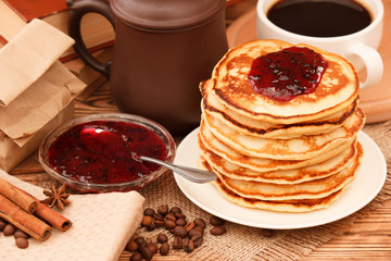 Fresh baked wheat pancakes with black currant jam and coffee