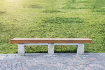 Fototapeta premium Relax and take a rest concept. Wood chesterfield with bricks floor and green grass in park or garden. Advertising background. Picture for add text message. Backdrop for design art work.