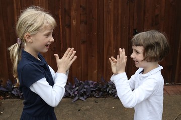 Two girls playing pat a cake