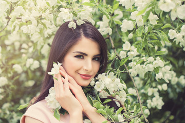 Beautiful Young Woman with Spring Flowers on Floral Spring Background, Female Face Closeup