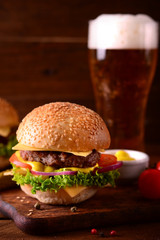 Fresh burger closeup and beer. Wooden rustic background. Top view