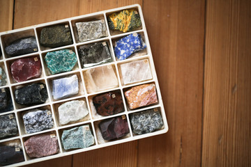 Collection of minerals in box on wooden background