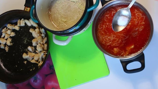 The cook pours salt into a tablespoon and adds to the cooked tomato soup. After that, thoroughly mixes the prepared dish.