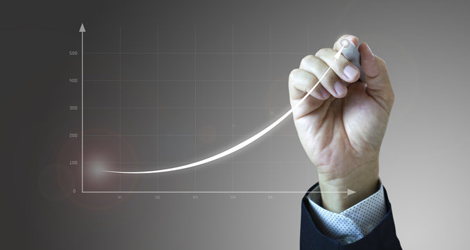Close up of a businessman’s hand drawing an exponential line curve showing of business growth and success rapidly.