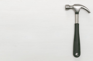 Hummer tool isolated on white wooden surface background with copy space. Construction concept background.