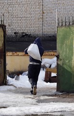 Man in a dump in the winter shift bags  