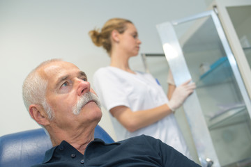 Fototapeta premium calm mature man sitting in clinic near blood test set
