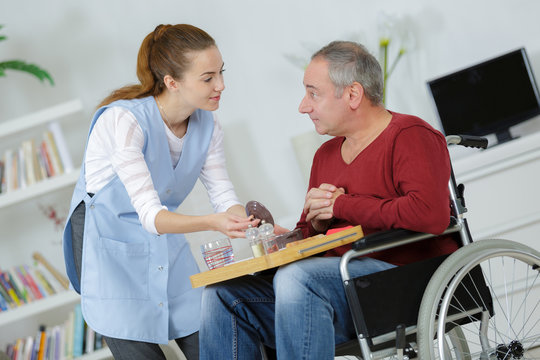 nurse with middle age man patient sitting on a wheelchair