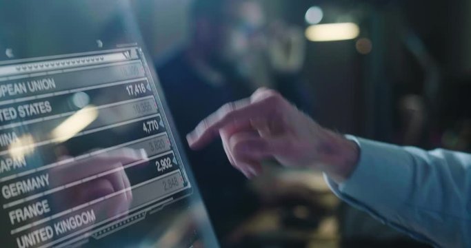 A man in his own studio uses a glass monitor with holography to design, navigate and build. Concept of: navigation, future, technology, engineer.