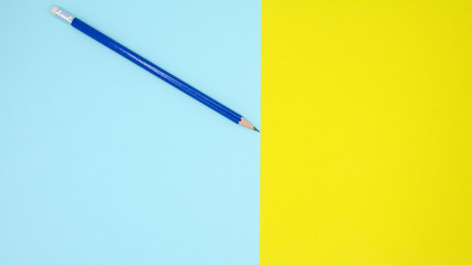 blue pencil on blue and yellow paper - background