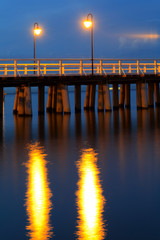 Fototapeta na wymiar Sea pier at the Baltic Sea shoreline in Gdynia Orlowo, Poland at evening twilight